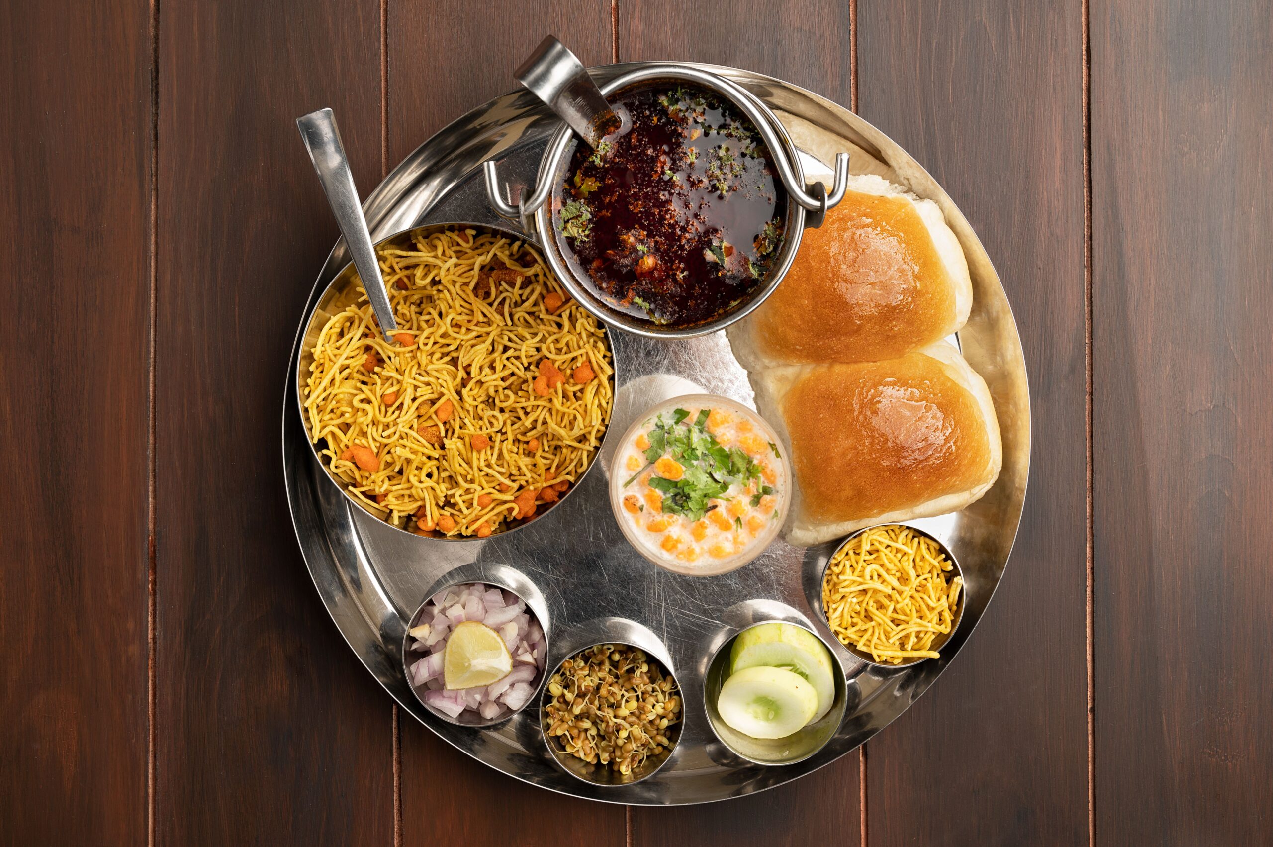 Delicious authentic Misal Pav meal on a traditional thali, showcasing Indian street food culture.